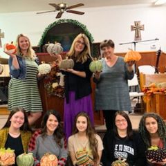 Young women and girls holding decorated pumpkins in the sanctuary